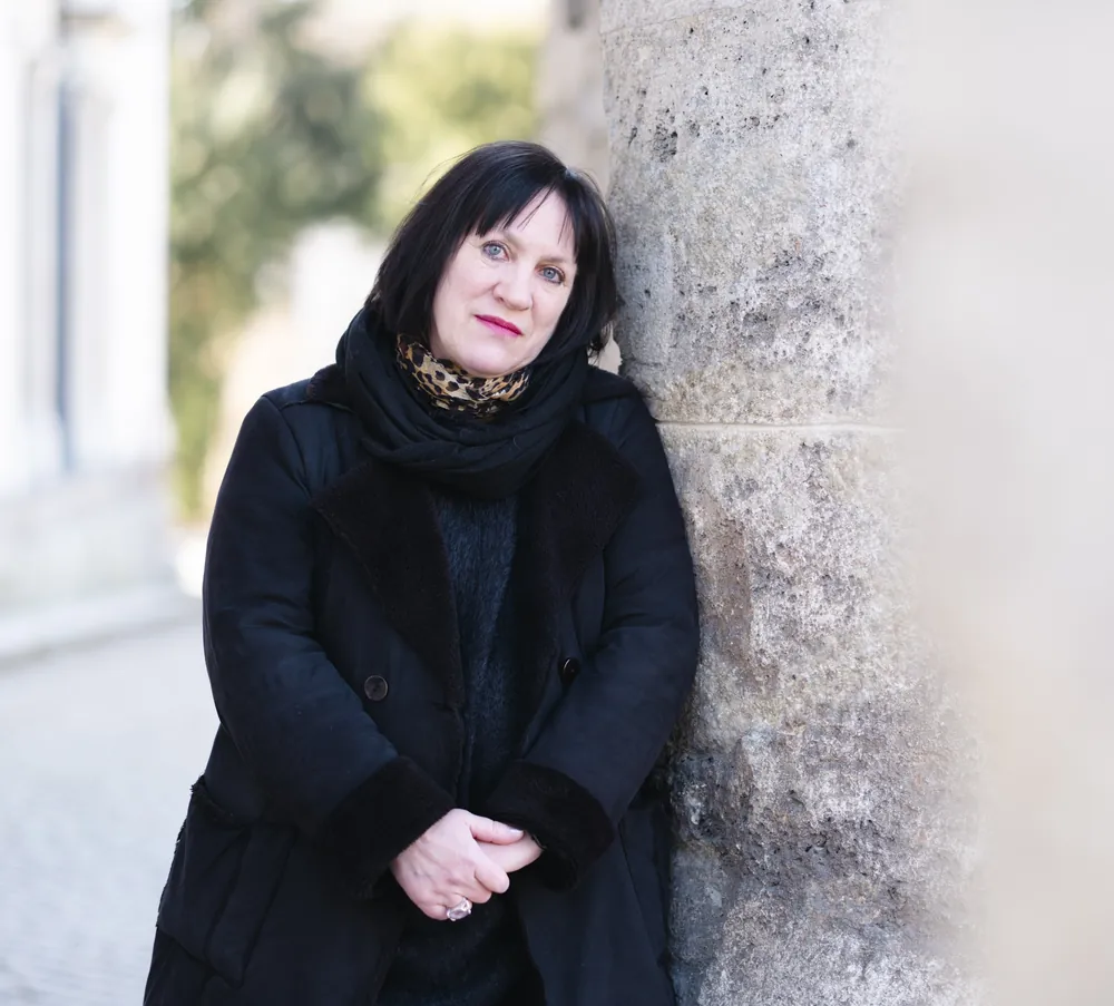 Kristina Rössler-Lehnhoff im schwarzen Mantel an einer Mauer