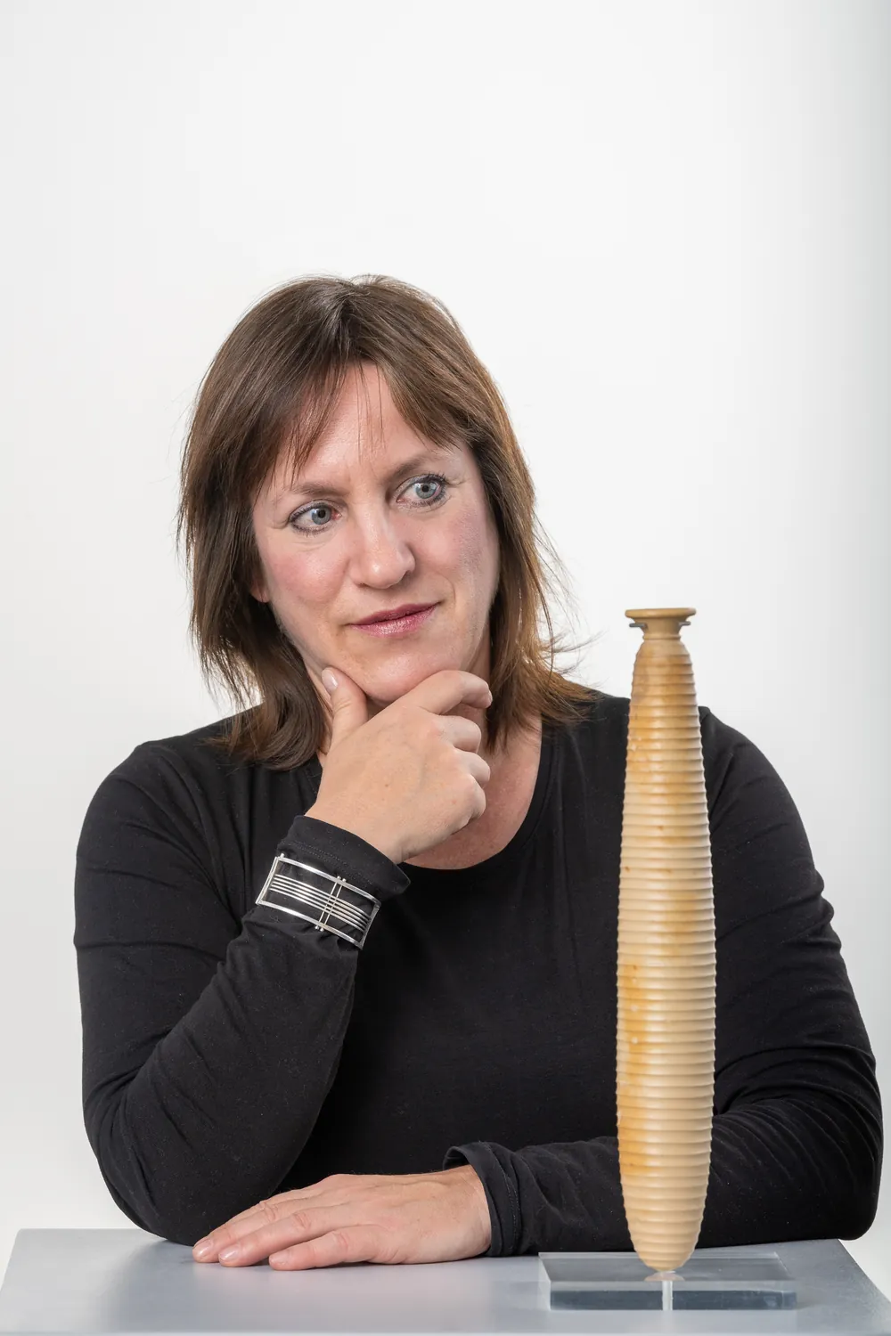 Kristina Rössler-Lehnhoff am Tisch neben einer Holzskulptur
